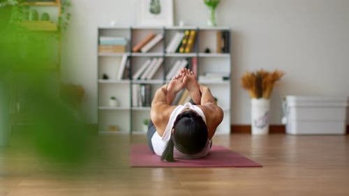 Une femme asiatique athlétique pratique l'arc de yoga ou la pose du dhanurasana