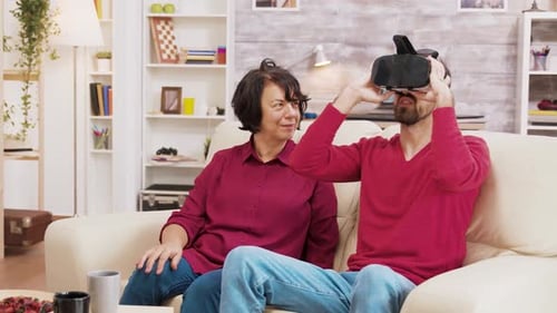 Neffe zeigt seiner Großmutter, wie man eine VR-Brille benutzt
