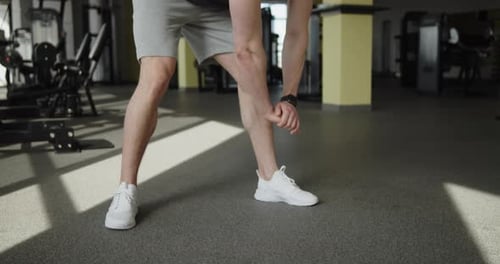 Young Muscular Athlete Works Out in a Modern Gym Making Warmup Exercises