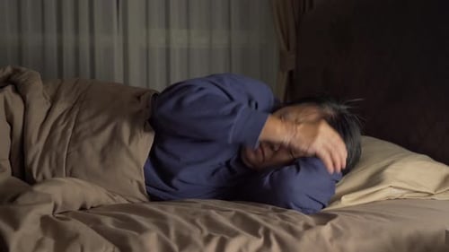 Worried Adult Tossing and Turning in Bed