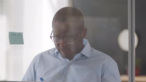 Black Businessman Working with Sticky Notes in Office