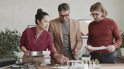 Architects Review Building Model and Plans in Office