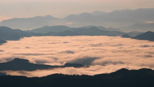 Golden Clouds Fill Mountain Valley at Sunrise