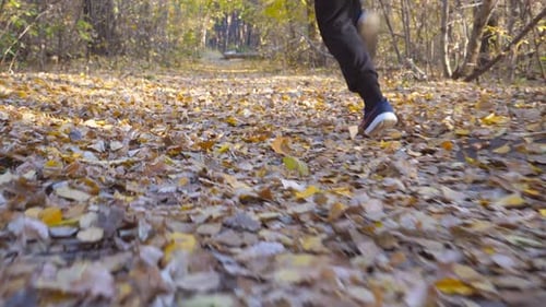 Young Unrecognizable Man Runs at Autumnal Forest Path