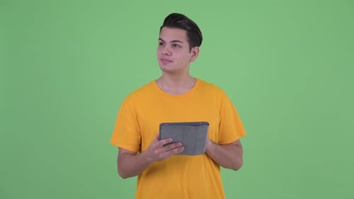 Young Man Using Tablet on Green Screen