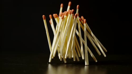 Matches Falling in Slow Motion on Black Surface
