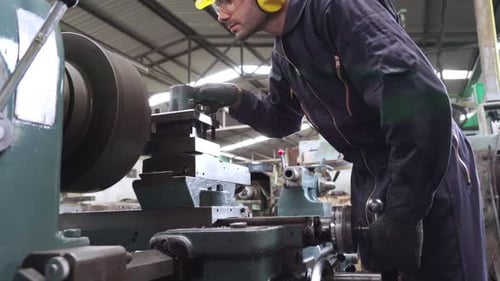 Trabajador de fábrica inteligente que usa la máquina en el taller de la fábrica