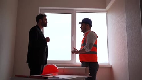 Side View of Architect and Engineer Talking and Shaking Hands