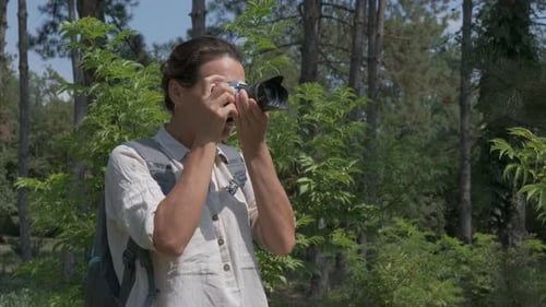 Woman Taking Photos in a Green Forest