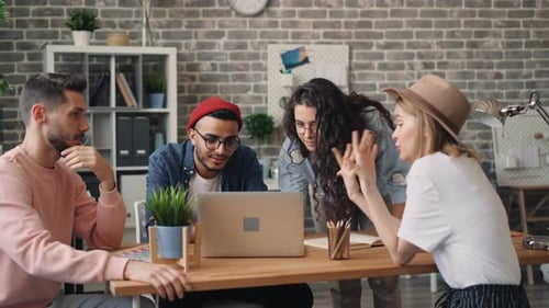 Office Team Collaborating Around a Laptop