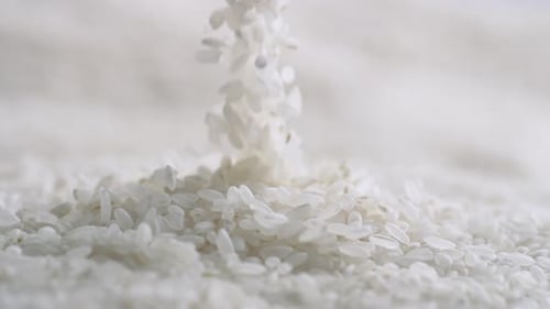 Close up of White Rice Pouring onto Pile