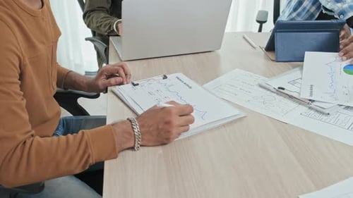 Colleagues Analyzing Financial Statistics during Meeting