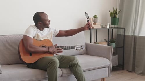 Man Plays Guitar and Records Video at Home