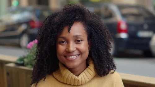 Portrait of a Smiling Brazilian Woman with Curly Hair Looking at Camera