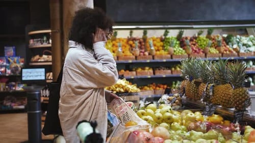 Mujer afroamericana en camisa de lino con bolsas ecológicas
