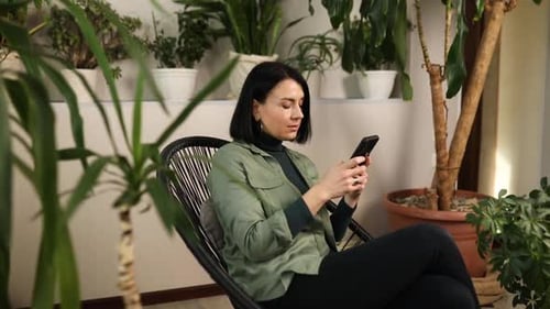 Woman Relaxing at Home Using Smartphone