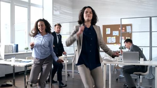 Team of Young Business People Smiling and Dancing in Office