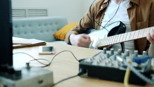 Adult Playing Electric Guitar in Home Studio