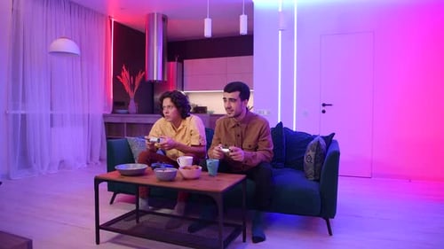 Young Adults Playing Video Games on a Couch
