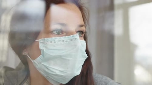 Woman Wearing Medical Mask Looking Out Window