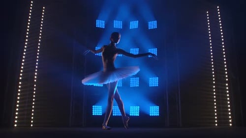Elegant Ballerina Dancing Under Blue Stage Lights