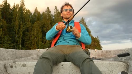 Fisherman Fishing From Boat. Young Adult Man Rowing A Boat And Fishing On Lake.