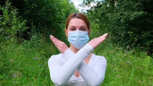 Woman in Mask Expressing Rejection in Forest Setting