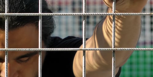 Man Holding Fence Talking with Colorful Background