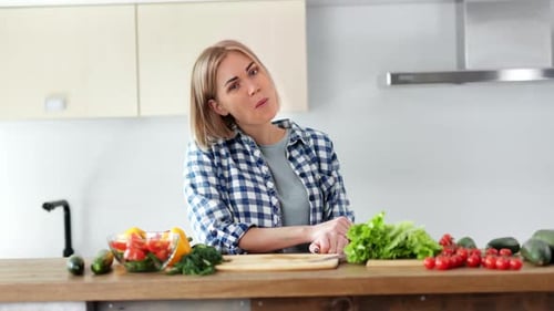 Woman with Vegetables Smiles in Bright Kitchen