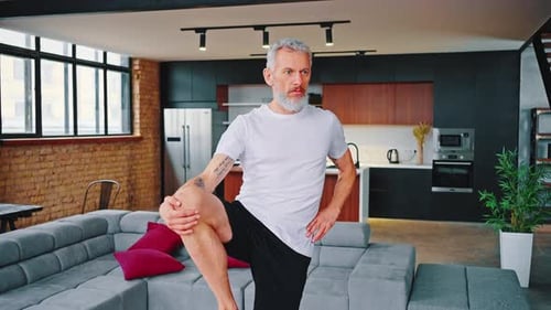 Hombre mayor deportivo practicando yoga en interiores
