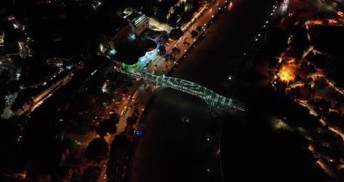 Night aerial view of Bridge of Peace and beautiful cityscape in the center of Tbilisi, Georgia 2022