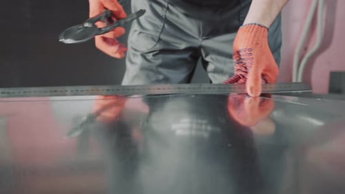 A Professional Engineer Works with a Metal Sheet. The Master Makes Incisions on a Metal Sheet To