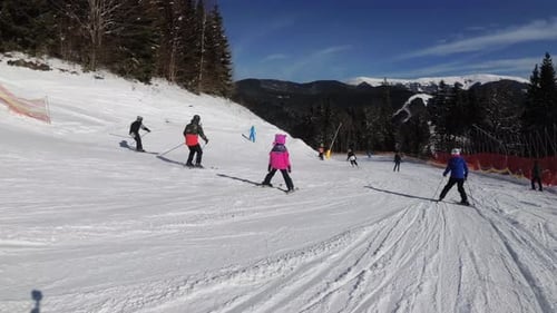 First-person View on Skiers and Snowboarders Slide Down on Ski Slope at Ski Resort