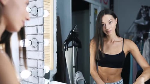 Young Woman Applying Makeup in Front of Mirror