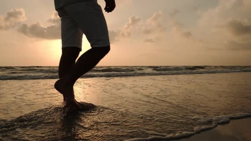 Close Up View of Male Walking on a Beautiful Beach During Sunset