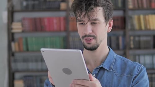 Jeune homme occasionnel utilisant la tablette au travail