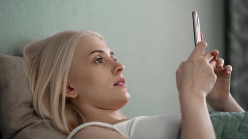 Relaxed Young Woman Using Smart Phone Surfing Social Media Checking News Playing Mobile Games or