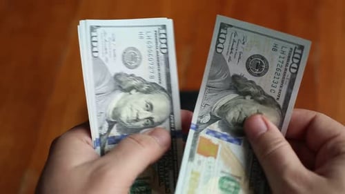 Hands Counting Stack of Cash from Black Wallet