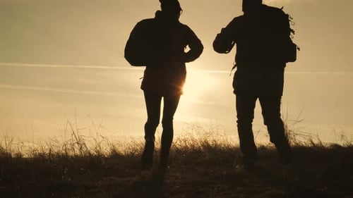 Happy Couple Man and Woman Tourist at Top of Mountain at Sunset Outdoors During a Hike