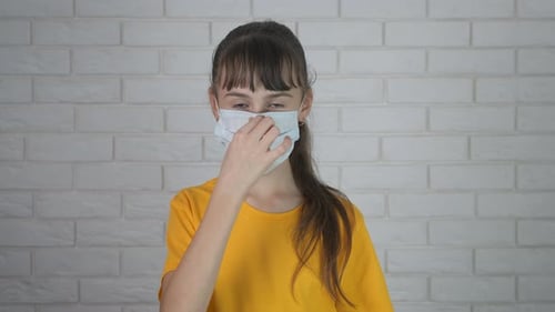 Young Child Wearing Face Mask with Sign