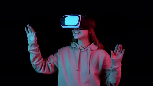 Young Adult Using Virtual Reality Headset in Dark Studio