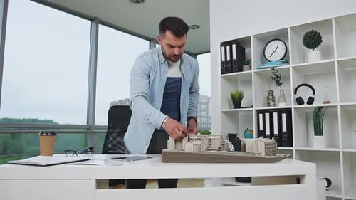 Bearded Engineer-Designer Using Ruler Taking Measurements of Constructed Building's Model