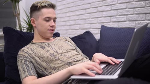 Young Adult Chatting on Laptop While Relaxing
