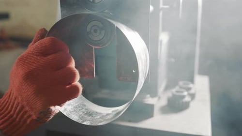 Ein professioneller Ingenieur arbeitet mit einem Metallblech. Der Meister macht Einschnitte auf einem Blech