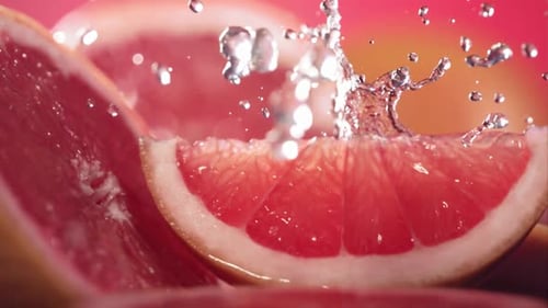 Refreshing Water Splashing on Sliced Pink Grapefruit