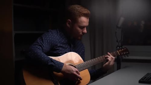 Man Plays Acoustic Guitar and Sings at Night