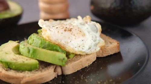 Avocado Toast with Egg on Black Plate