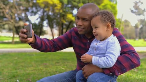 Happy Adult and Child Take Selfie in Park
