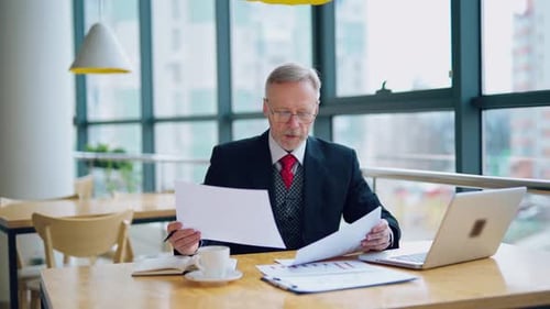 Man Reviewing Paperwork in Modern Office
