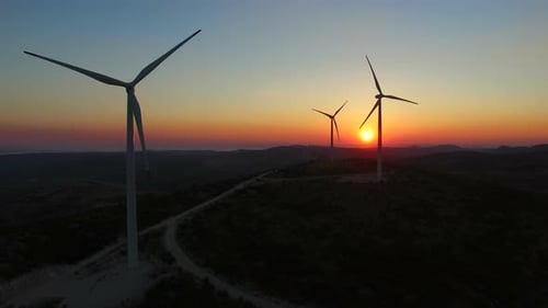 Aerial view of sustainable windmills at beautiful colorful sunset